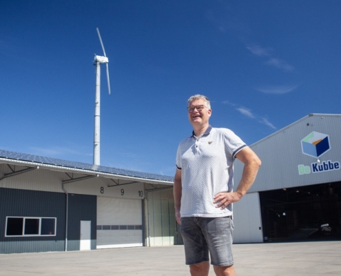 Dick van Tilburg voor zijn windmolen en bedrijfspand